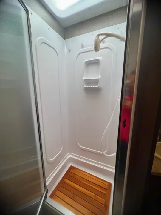Interior of the shower stall with wood slat floor mat