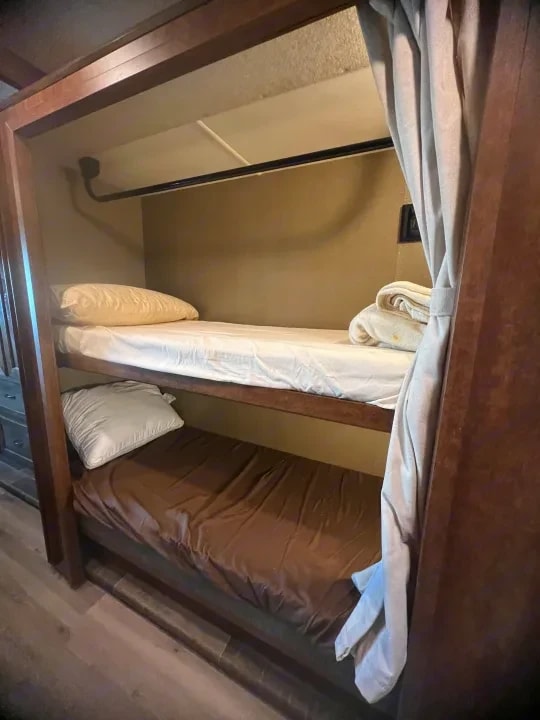 Close view of the twin bunk beds with folded linens on the top bunk