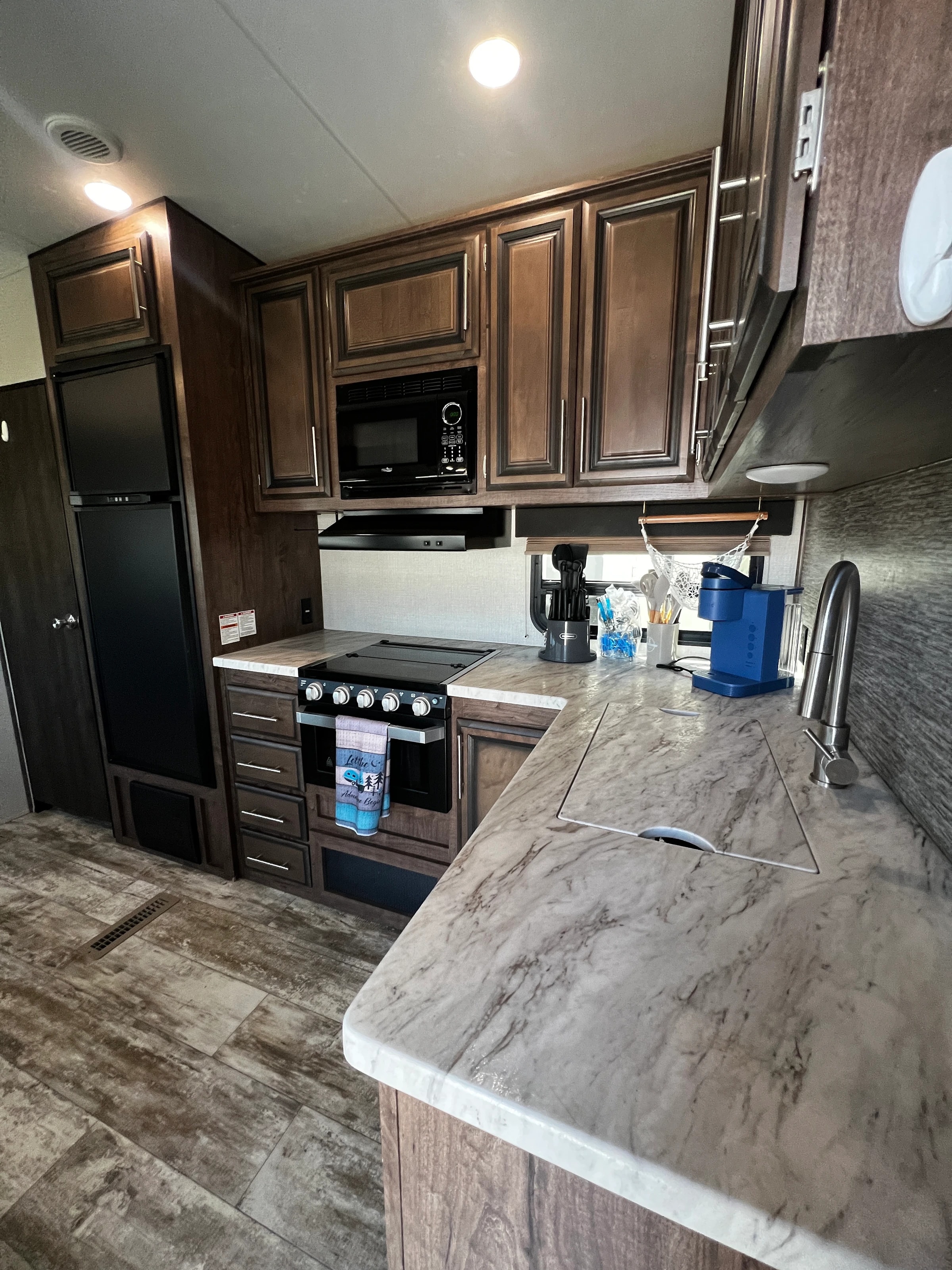 Kitchen counter with sink, coffee maker, range, and microwave