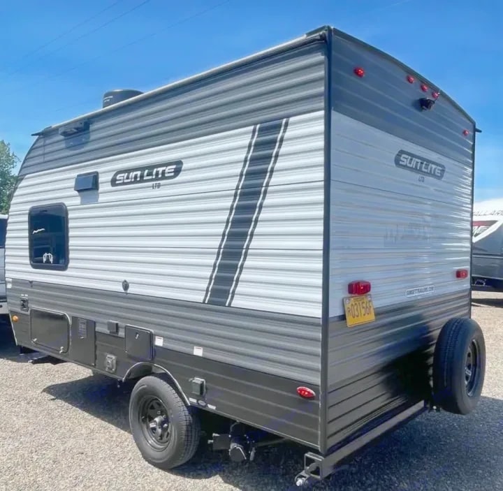Rear three-quarter view of the trailer showing taillights and spare tire