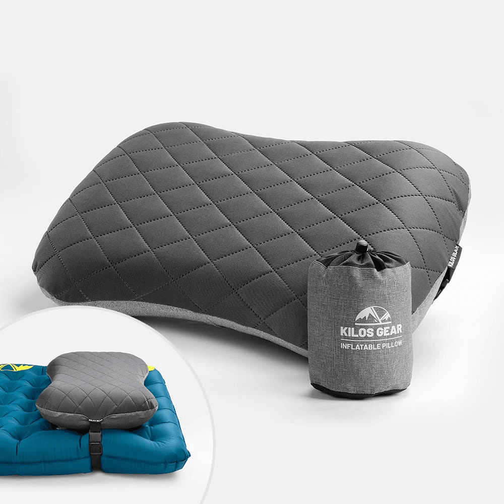 Grey quilted inflatable camp pillow next to its stuff sack