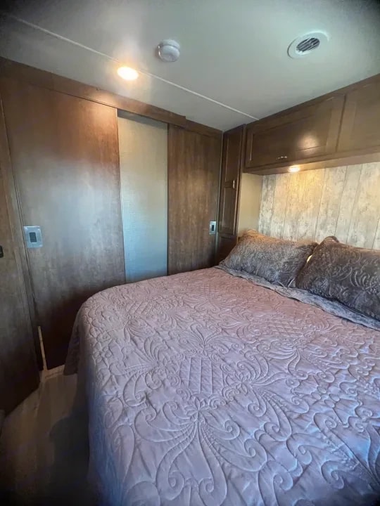 Bedroom bed with pink quilted bedding viewed from a different angle