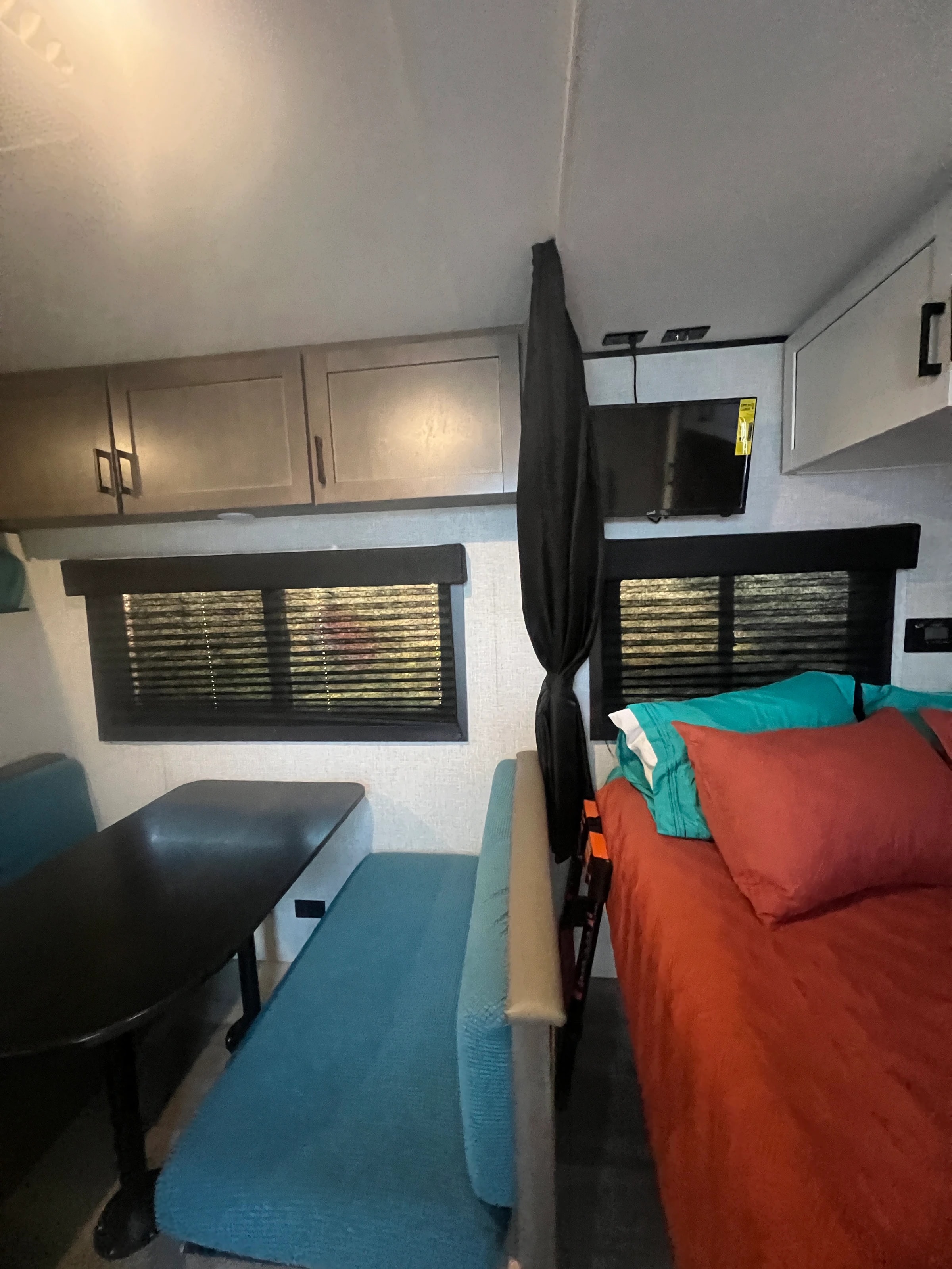 Teal booth dinette beside the front queen bed