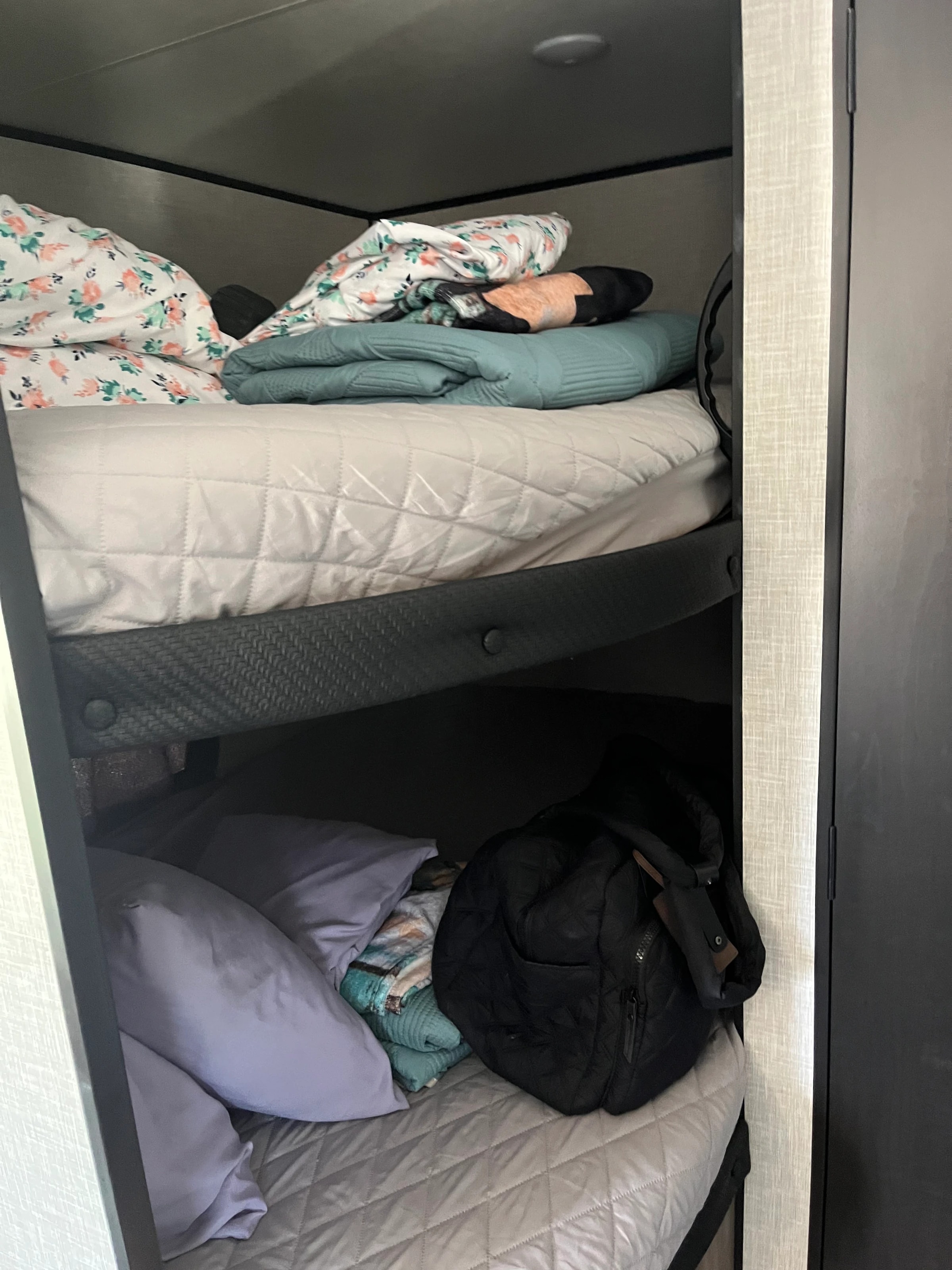 Underbed storage compartment holding folded bedding and pillows
