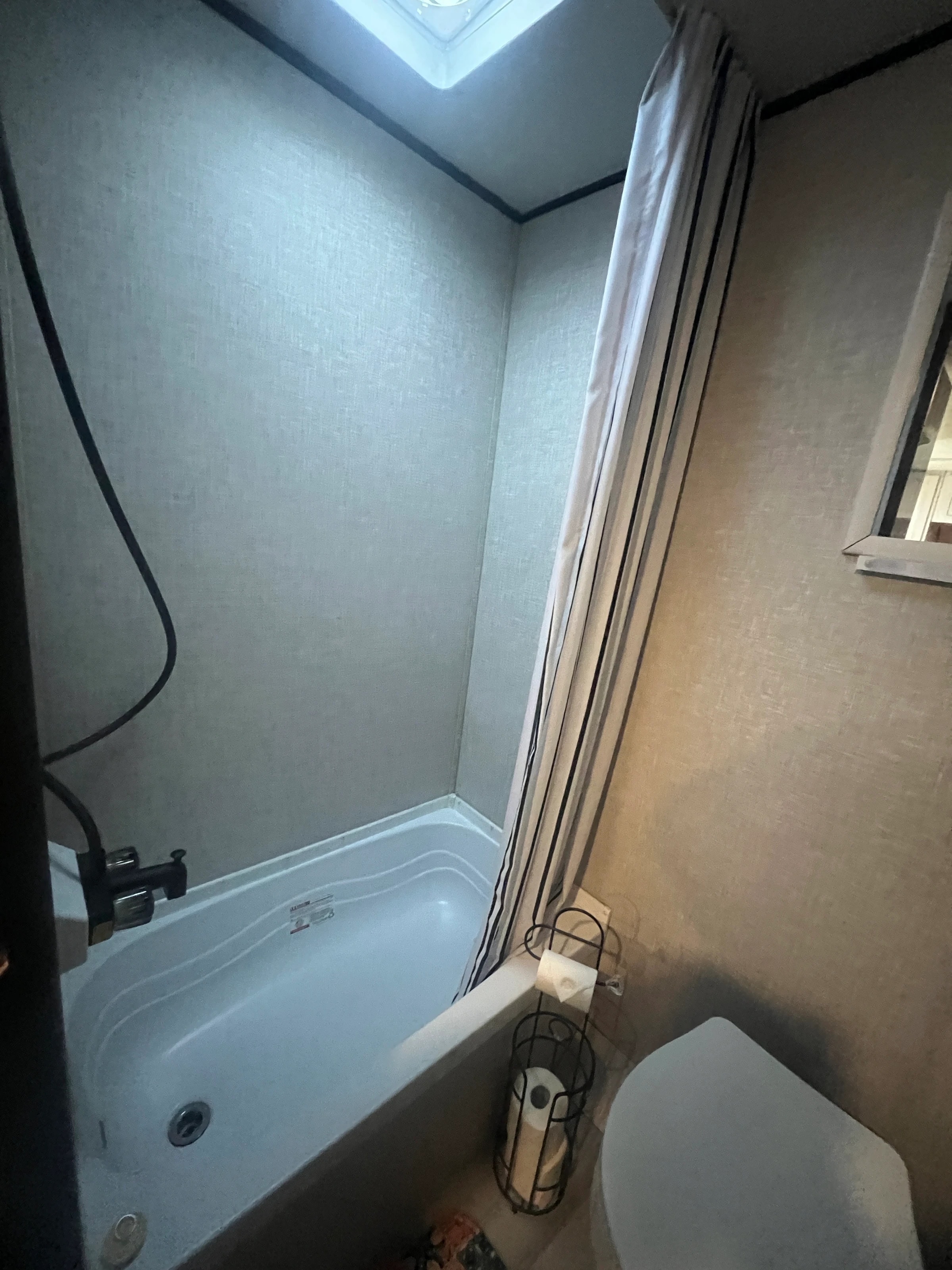 Bathroom with a tub and shower combination beside the toilet