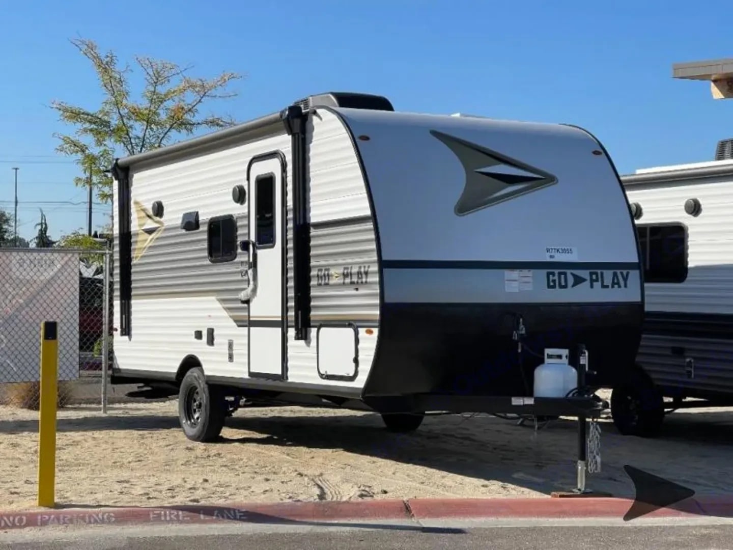 Three-quarter front view of the trailer with awning extended and propane tank on the tongue