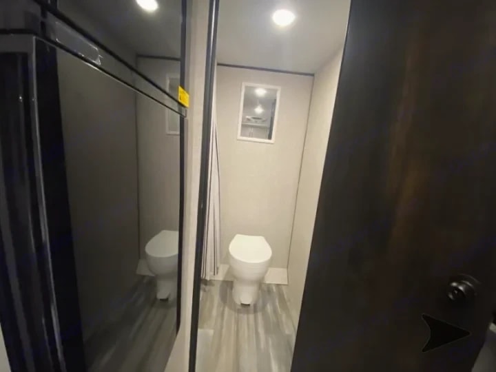Bathroom toilet area with mirrored closet doors