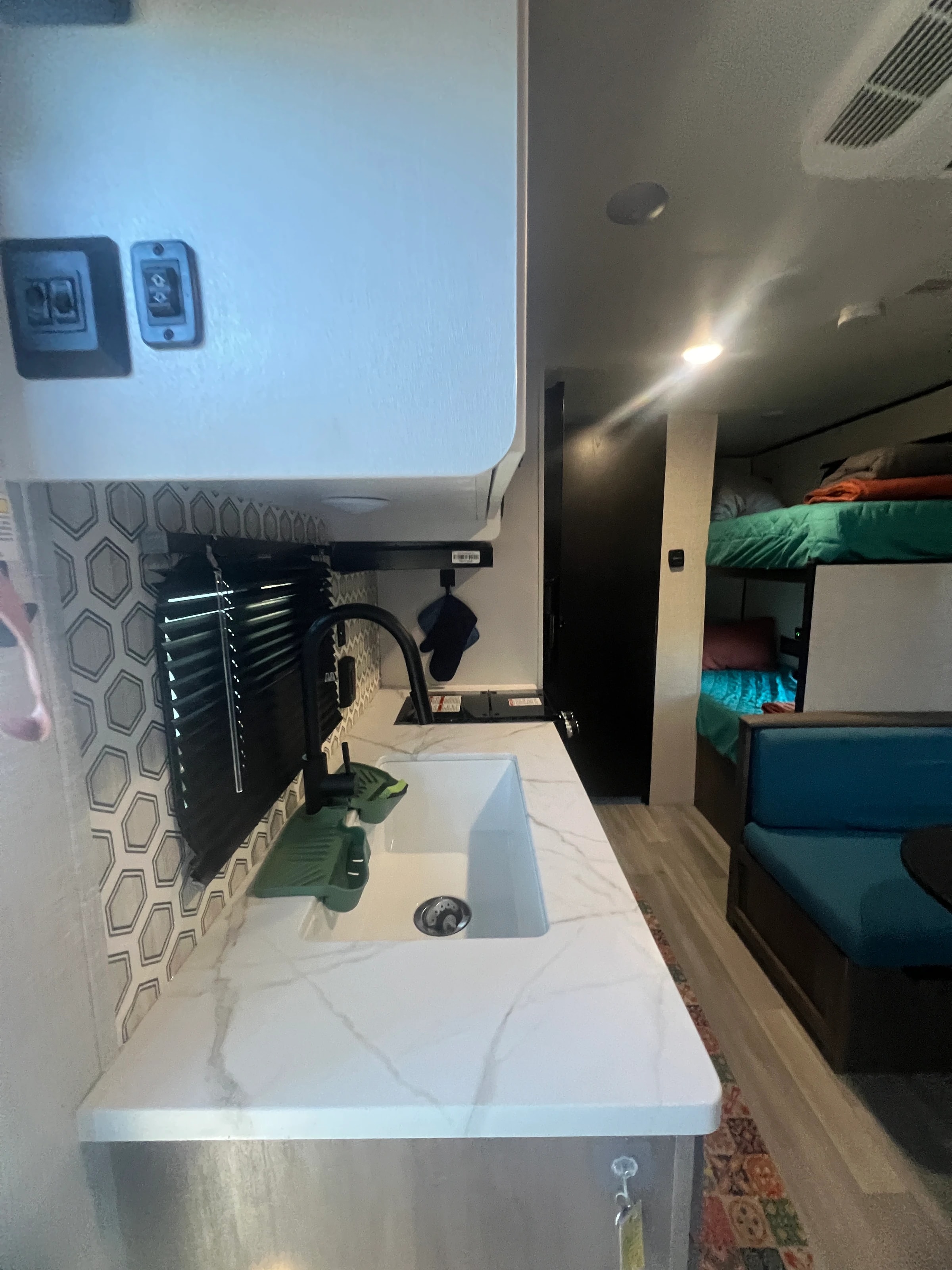 Kitchen counter and sink with the dinette and bunks behind