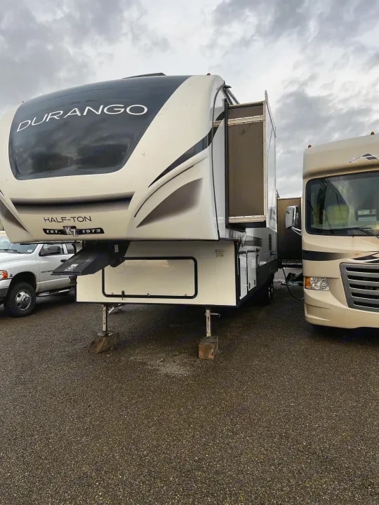 Front three-quarter exterior view parked among other RVs under a cloudy sky
